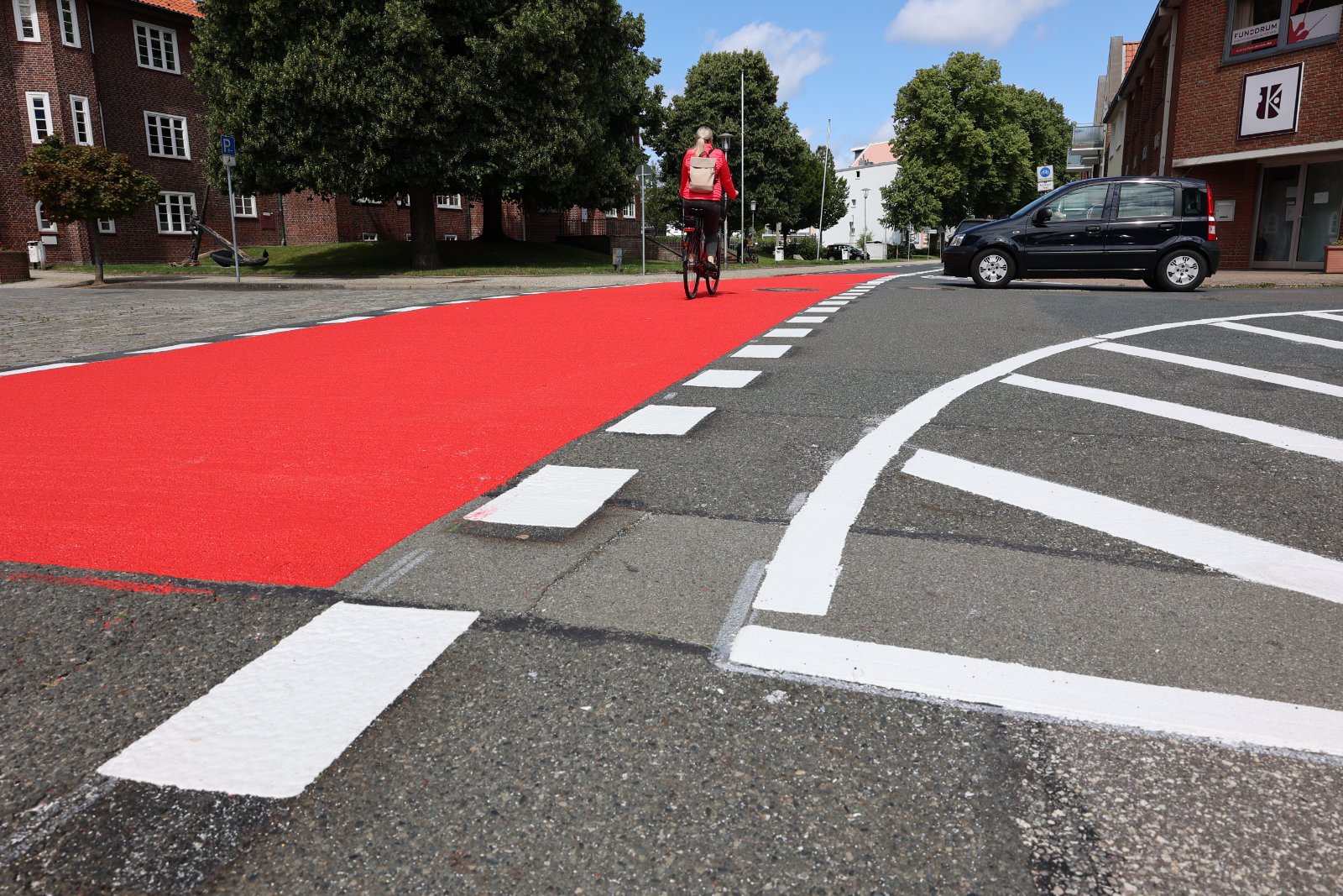 Die dauerhafte Gestaltung erfolgt nach dem „Cuxhavener Standard“ für Fahrradstraßen. Dieser umfasst großflächige Fahrrad-Piktogramme und rote Markierungen an den Ein- und Ausfahrten der Fahrradstraßen, unterbrochene Breitstrichmarkierungen als durchgängiges Gestaltungselement sowie rot eingefärbte Kreuzungsbereiche zur besseren Wahrnehmung. Foto: Stadt Cuxhaven